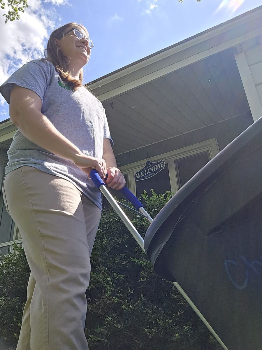Stephanie moving a holiday bin with a hand truck
