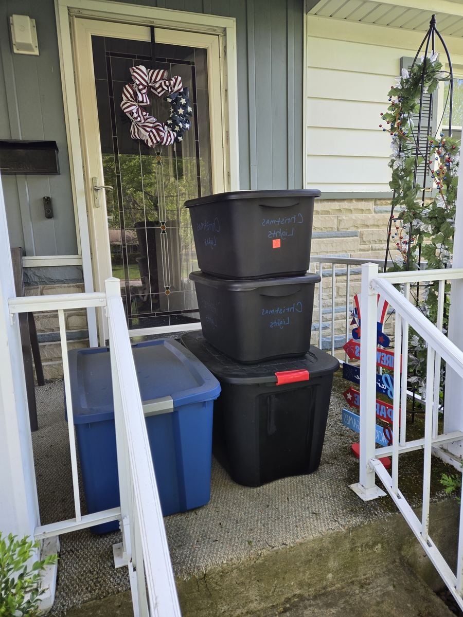 Holiday decoration bins waiting on a front porch for pickup